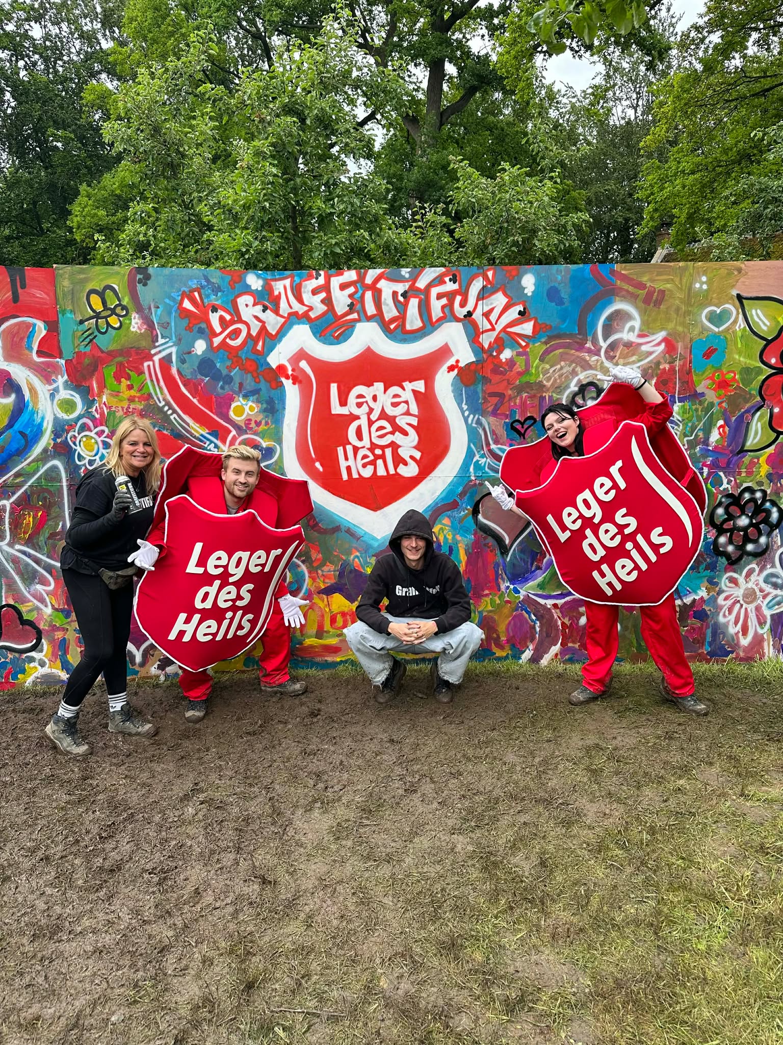 A team celebrating the graffiti artwork they painted together during a creative team building session
